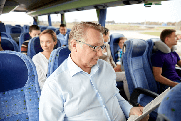 גבר עם משקפיים באוטובוס קורא עיתון